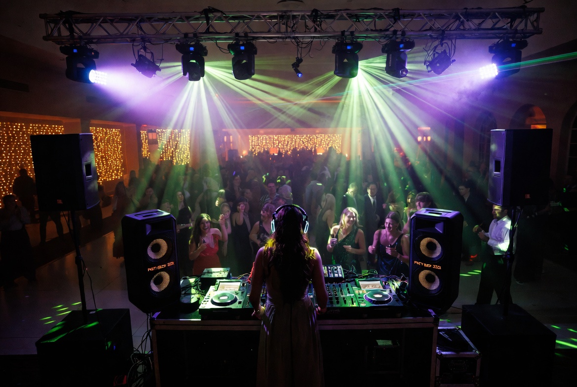DJ setup with lasers, moving lights and a full dance floor